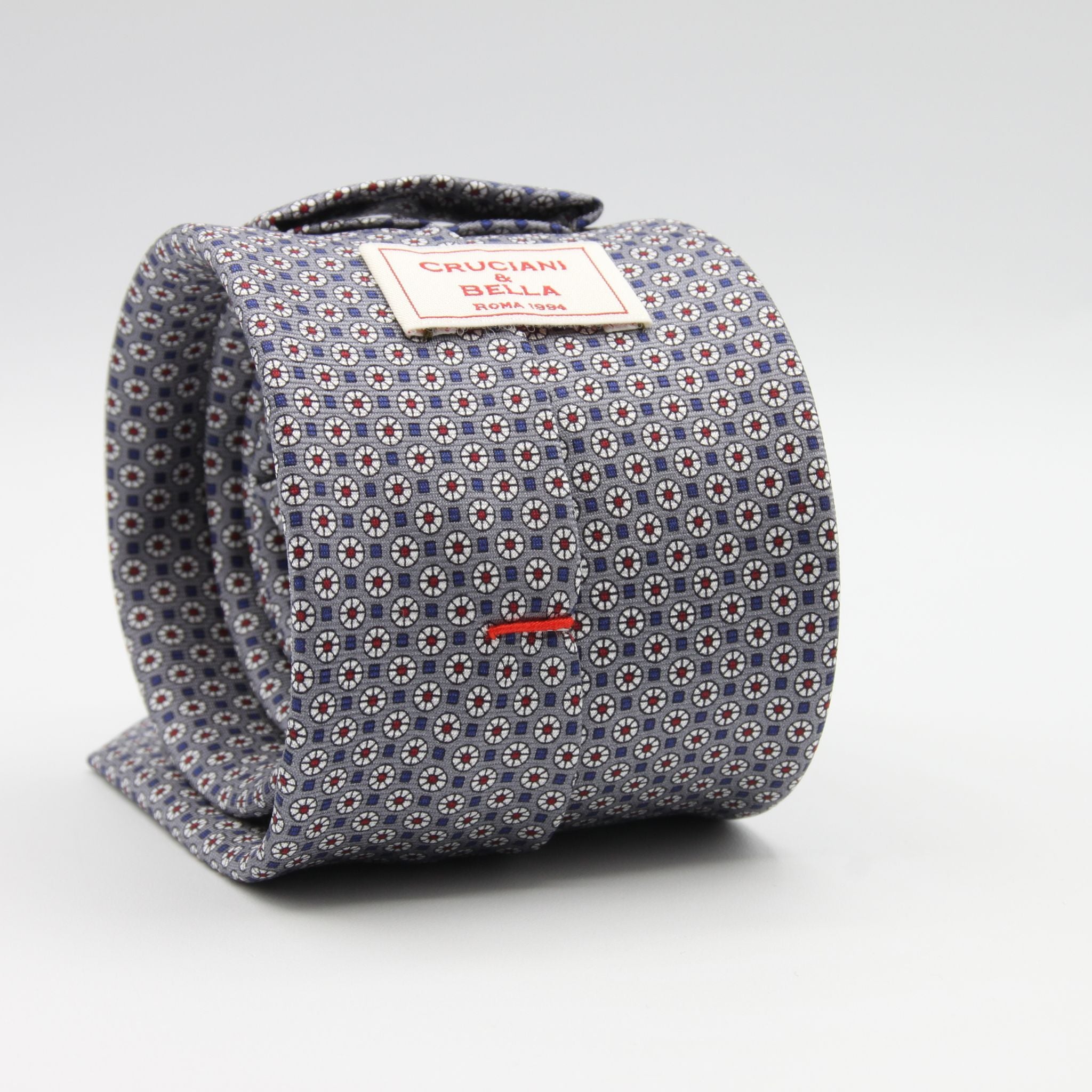 Cruciani &amp; Bella
100% Printed Silk

Self-Tipped
Grey, White, Red and Blue Motif Tie
Handmade in Rome, Italy.
8 cm x 150 cm
#9429