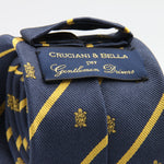 Cruciani &amp; Bella per Gentlemen Drivers
100% Woven Jacquard Silk
Tipped
Blue, Gold Stripes Crest Tie
Handmade in Italy
8 cm x 150 cm
#9204