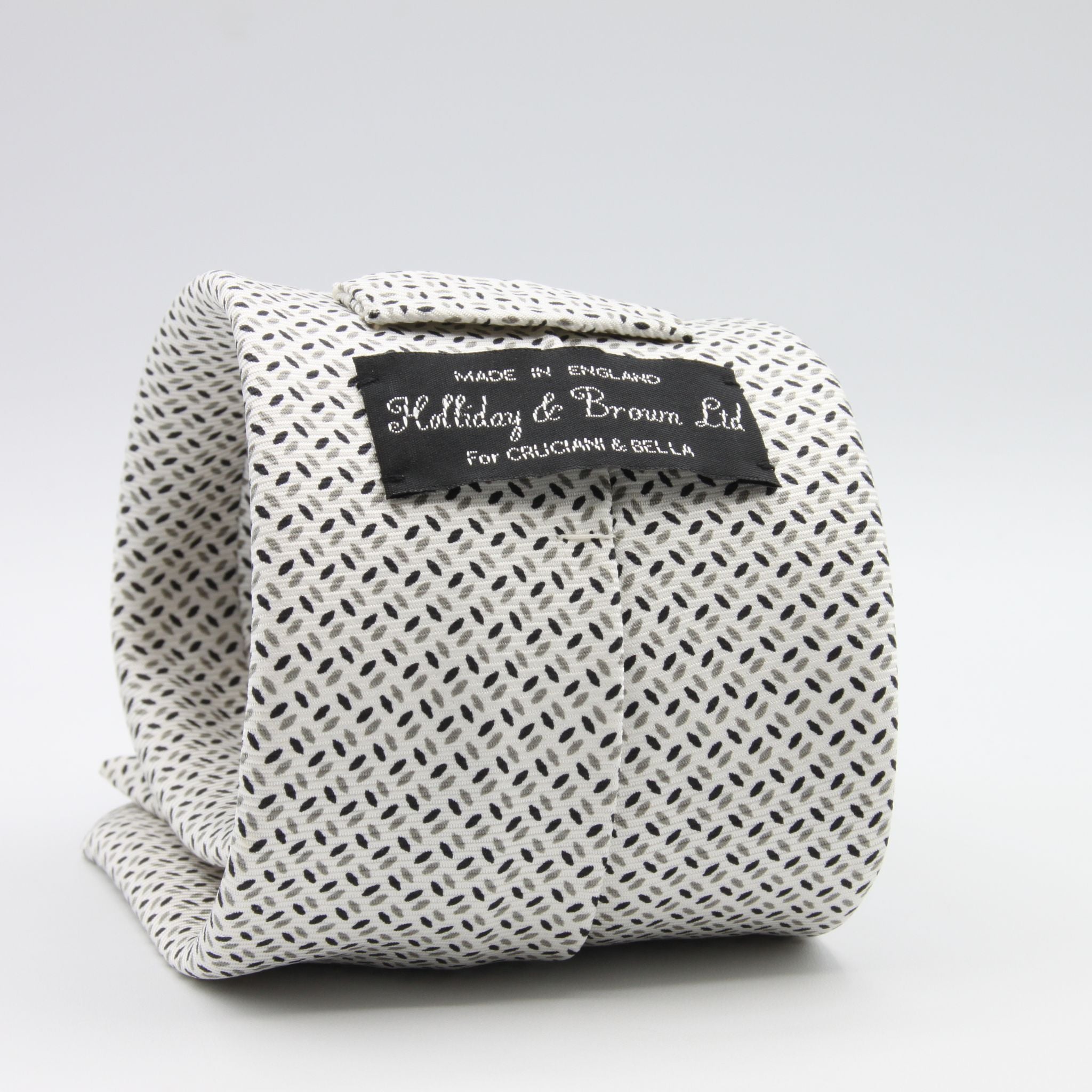 Holliday &amp; Brown for Cruciani &amp; Bella
Vintage Handmade in England
100% Printed Silk
Tipped
Off-White, Grey and Black motif Tie

9,5 cm x 150 cm
6602
