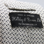 Holliday &amp; Brown for Cruciani &amp; Bella
Vintage Handmade in England
100% Printed Silk
Tipped
Off-White, Grey and Black motif Tie

9,5 cm x 150 cm
6602