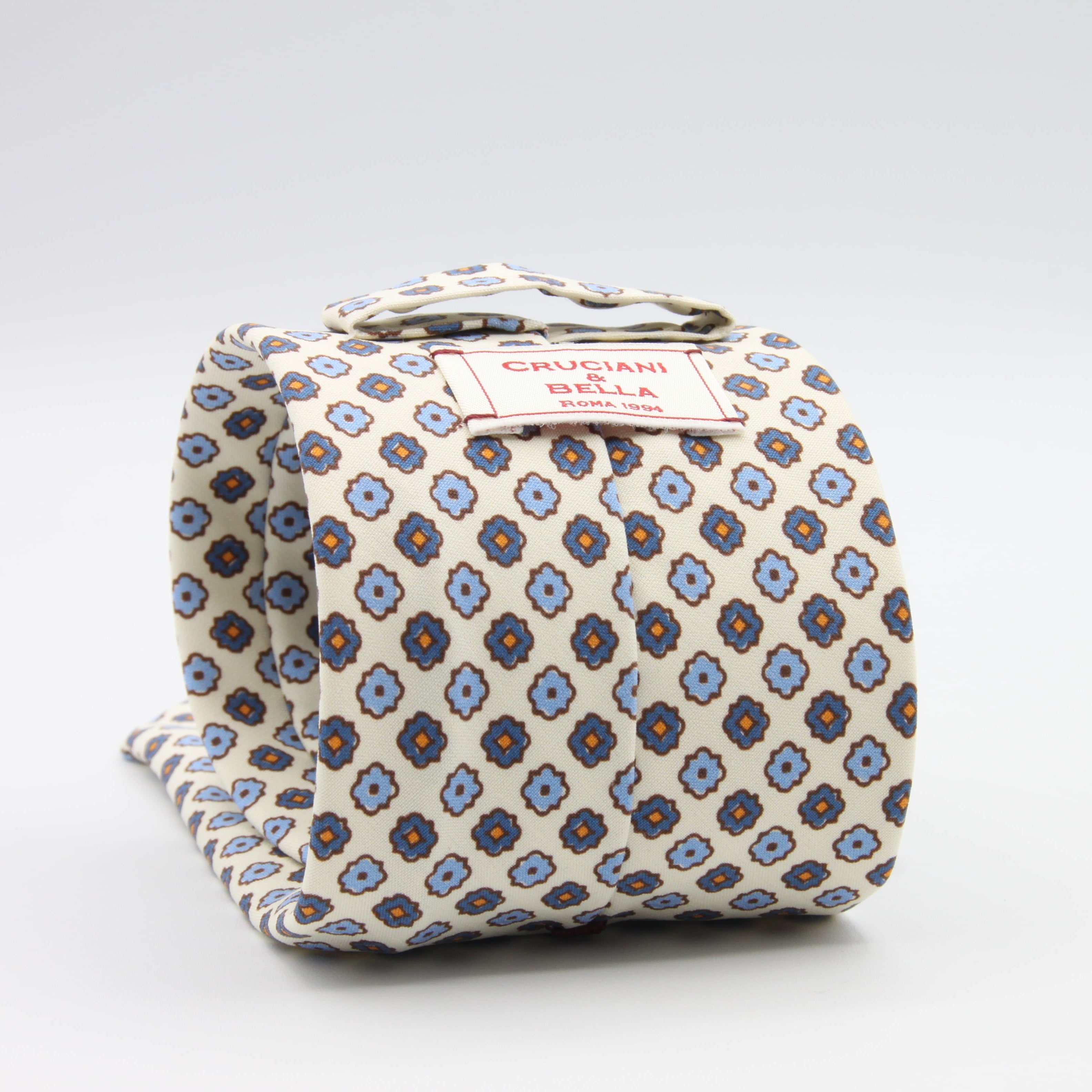 Cruciani &amp; Bella Tie
Handmade and Printed in Italy
Unlined
Hand Rolled
Off-White, Blue and Orange Tie
100% Printed Madder Silk
8 X 150 Cm
#9539