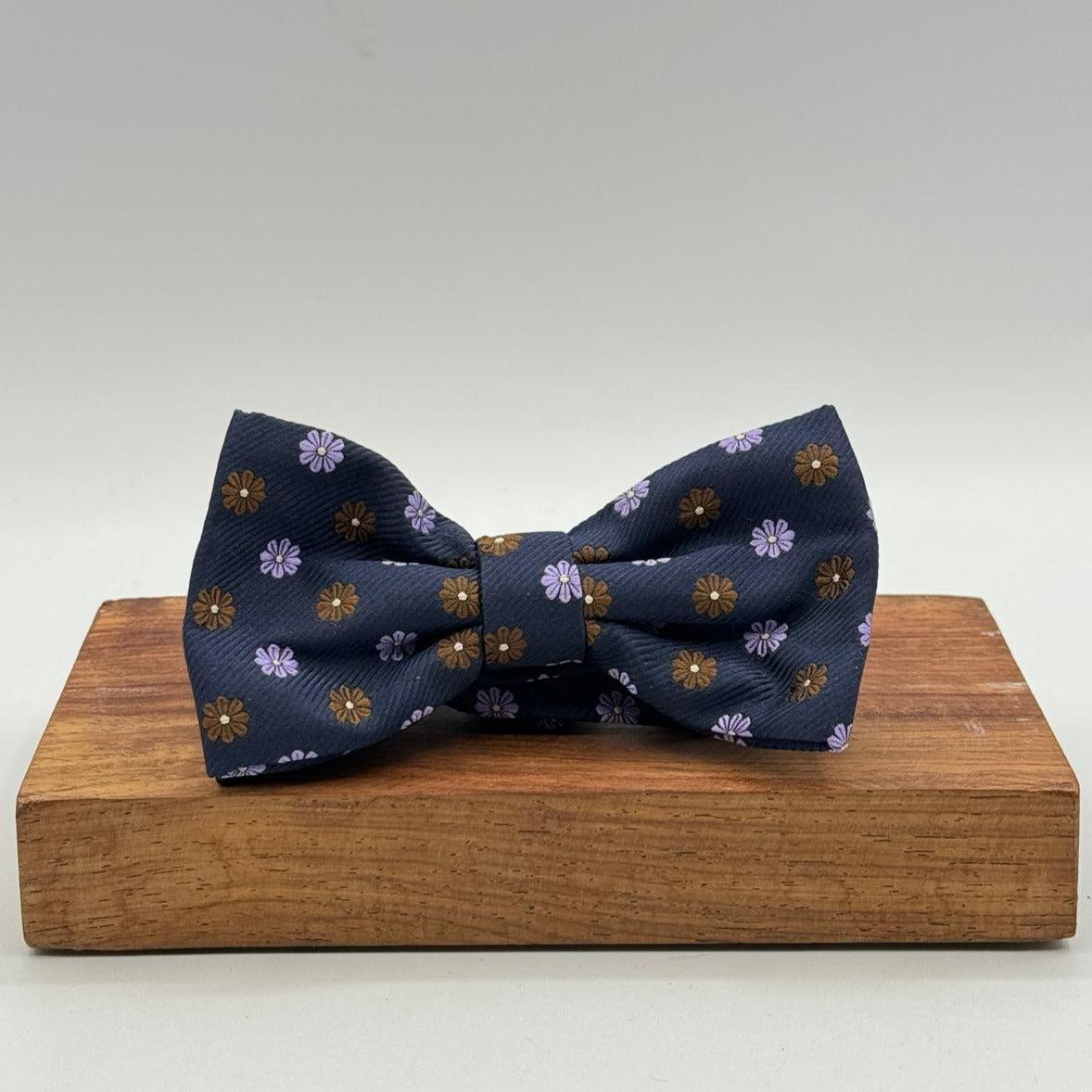 <ul> <li>Cruciani &amp; Bella Bow Tie</li> <li>100% Woven Silk Jacquard Made in England</li> <li>Handmade in Italy</li> <li>Navy Blue, Brown and Light Violet motif</li> <li>Handcrafted in Italy</li> <li>Coated metal Labels</li> <li>Bow Ties</li> </ul>