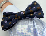 <ul> <li>Cruciani &amp; Bella Bow Tie</li> <li>100% Woven Silk Jacquard Made in England</li> <li>Handmade in Italy</li> <li>Navy Blue, Brown and Light Violet motif</li> <li>Handcrafted in Italy</li> <li>Coated metal Labels</li> <li>Bow Ties</li> </ul>