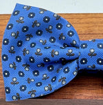 <ul> <li>Cruciani &amp; Bella Bow Tie</li> <li>100% Printed Madder Silk&nbsp;</li> <li>Handmade in Italy</li> <li>Olimpic Blue, Blue, Brown and Off White motif&nbsp;&nbsp;</li> <li>Handcrafted in Italy</li> <li>Coated metal Labels</li> <li>Bow Tie</li> </ul>