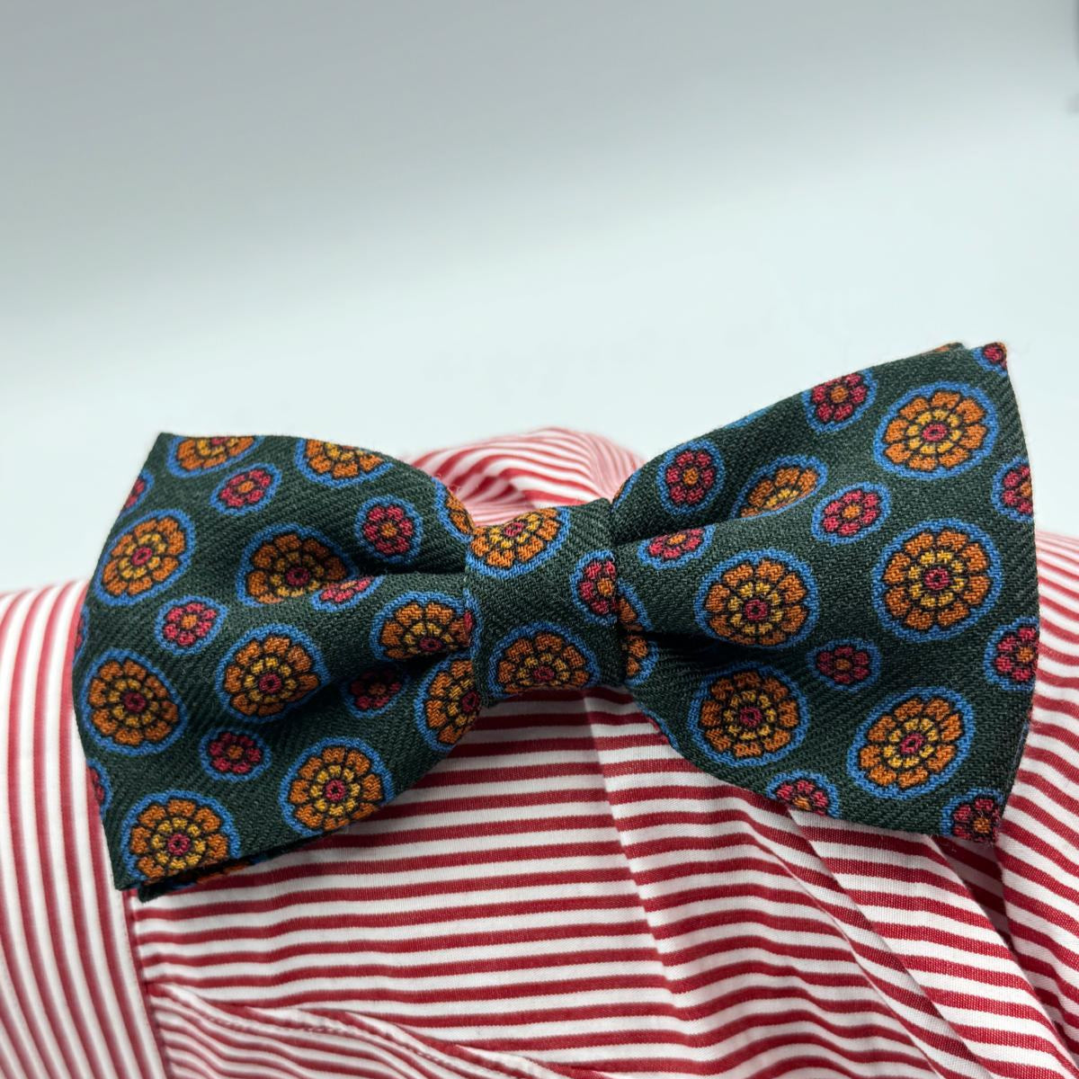 Cruciani &amp; Bella Bow Tie
85% Silk and 15 % Wool Made in England
Handmade in Italy
Green, Red, Orange, Light Blue and Yellow motif
Coated metal Labels
Bow Ties