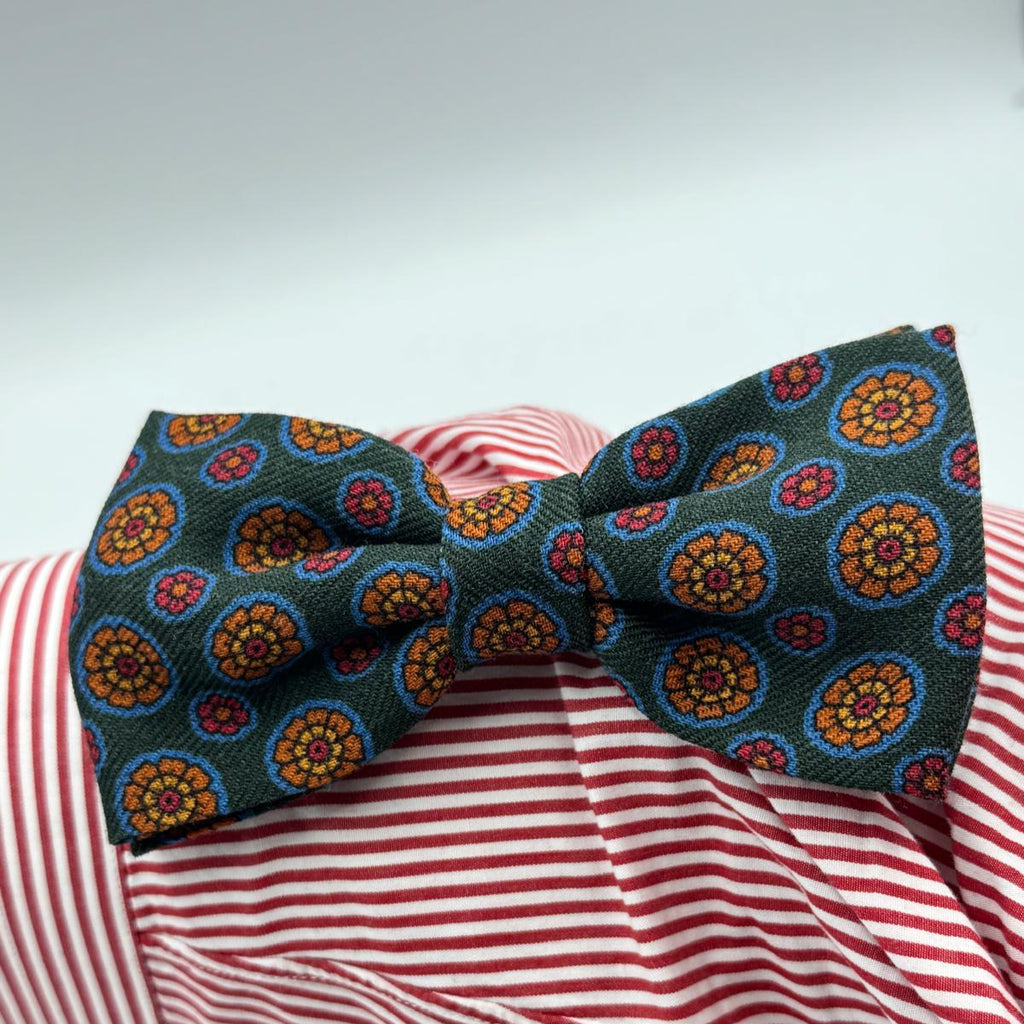 Cruciani &amp; Bella Bow Tie
85% Silk and 15 % Wool Made in England
Handmade in Italy
Green, Red, Orange, Light Blue and Yellow motif
Coated metal Labels
Bow Ties