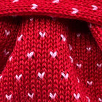 Cruciani &amp; Bella
100% Cotton
Knitted Tie

Red, Light Pink Motif
Handmade in Italy
7,5 cm x 145 cm
New Old Stock