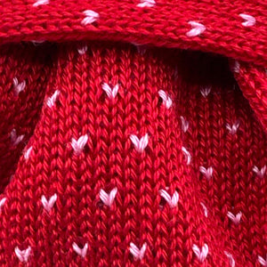 Cruciani &amp; Bella
100% Cotton
Knitted Tie

Red, Light Pink Motif
Handmade in Italy
7,5 cm x 145 cm
New Old Stock