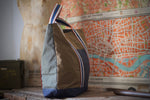 100% organic cotton - 7.5 oz ripstop cotton, 7mmx7mm - UK fabric, GOTS certified - FCF free and biodegradable fabric - Water repellent - Vegan dry wax finish - Royal blue/ Red/ Off white/ Oat handles - Belgian webbings, OEKO-TEX® Standard 100 certified - Antique brass rivets - Handcrafted, in house, in Italy, one piece at the time