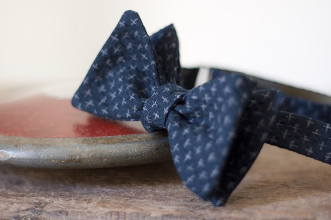 Noodles Bow Ties 100% Japanese Cotton  Blue navy, grey crosses Handcrafted in Italy Coated metal hardware  Olive green gabardine inside Hand-stitched labels Handmade boxes Self-tie bow ties