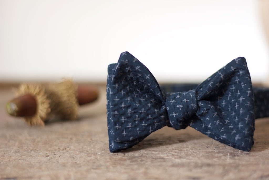 Noodles Bow Ties 100% Japanese Cotton  Blue navy, grey crosses Handcrafted in Italy Coated metal hardware  Olive green gabardine inside Hand-stitched labels Handmade boxes Self-tie bow ties